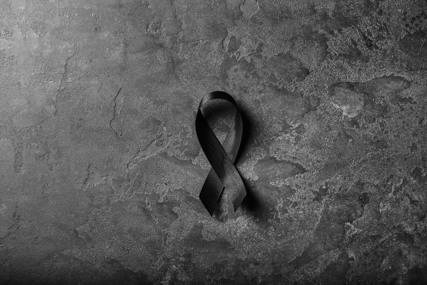 Black Mourning Ribbon on Grunge Background