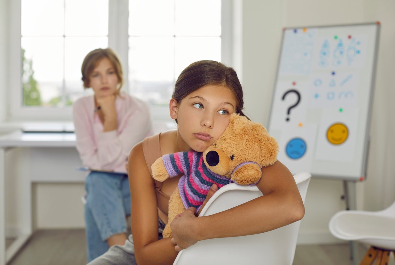 Troubled and Indifferent Preteen Girl Ignores Female Psychologist during  Session.